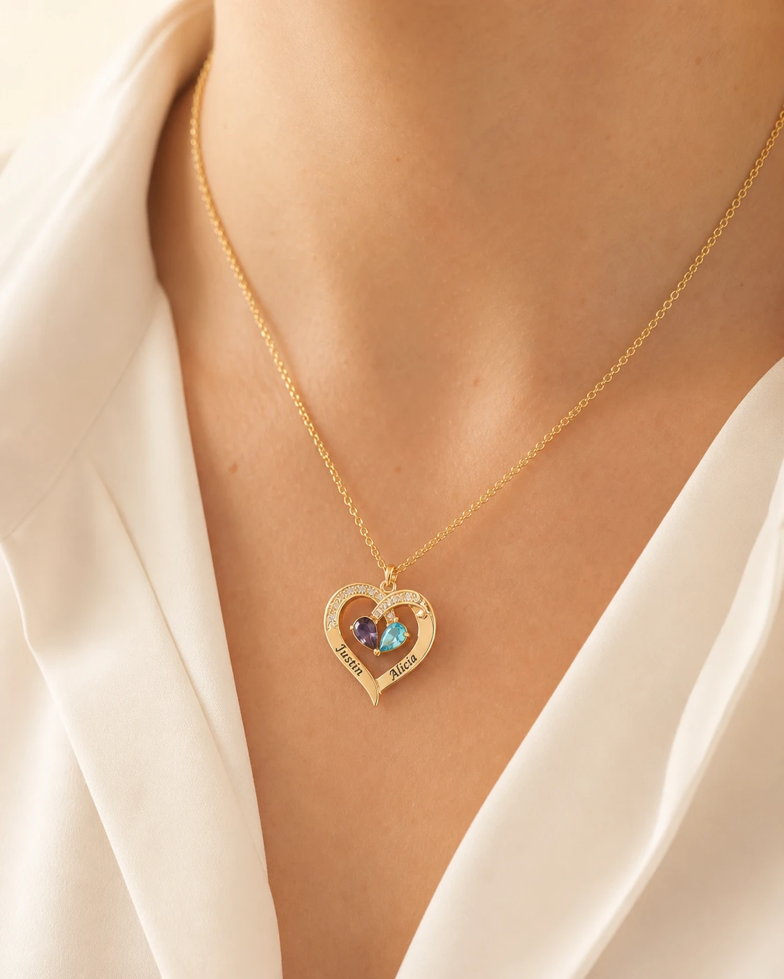 Two-name heart necklace worn with clearly visible engraving and birthstones