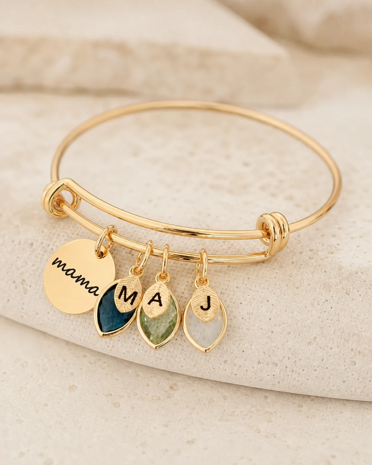Gold tone adjustable bangle with engraved family charms and colorful birthstones