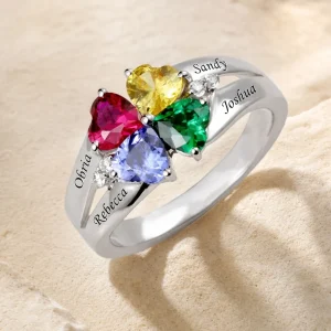 Engraved family birthstone ring photographed on an ivory stone surface